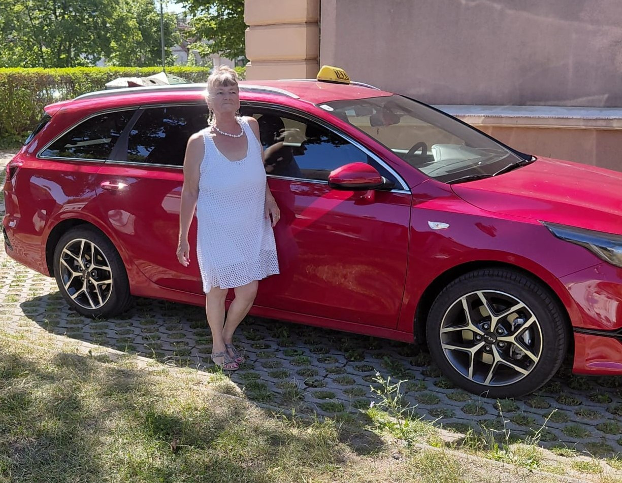 Renate vor ihrem roten Taxi in Baden